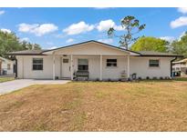 Charming white brick home with a cozy front porch and well-maintained lawn at 435 Lyle Pkwy, Bartow, FL 33830