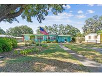 Charming single-story home with lush landscaping and an American flag on a well-maintained lawn at 503 Carolyn Dr, Lakeland, FL 33803