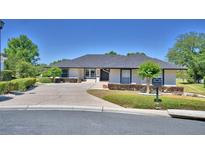 Charming single-story home featuring a well-manicured lawn, mature trees, and a welcoming driveway leading to the entrance at 5706 Manchester W Dr, Lakeland, FL 33810