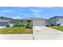 Charming single-story home with a well-manicured lawn, two-car garage, and welcoming entrance at 613 Sarner Pass Way, Winter Haven, FL 33881