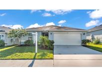 Charming single-story home with a manicured lawn and a two-car garage at 613 Sarner Pass Way, Winter Haven, FL 33881