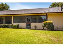 Charming backyard with a lush green lawn, mature landscaping, and a screened-in porch for enjoying the outdoors at 697 Broadmoor Cir, Winter Haven, FL 33884