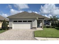 Charming single-story home featuring a brick driveway, attached two-car garage, and well-maintained landscaping at 7779 Lake James Blvd, Lakeland, FL 33810