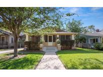 Charming bungalow-style home with a well-manicured lawn and inviting screened front porch at 805 Johnson Ave, Lakeland, FL 33801