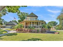 Charming two-story home with wraparound porch, mature landscaping, and a detached garage at 822 W Patterson St, Lakeland, FL 33803