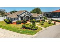 Beautiful gray house with manicured lawn, shrubbery, and a pathway to the front door at 942 Hanover Way, Lakeland, FL 33813