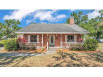 Charming single-story brick home featuring a welcoming front porch and meticulously maintained landscaping at 1055 Sunset Ave, Bartow, FL 33830