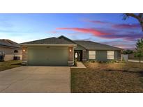Charming single-story home with a two-car garage, landscaped front yard, and neutral toned exterior paint at 1520 Caroline Ct, Bartow, FL 33830