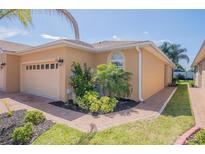 Charming home with manicured landscaping, a paver walkway, and a beige-colored exterior at 1620 Linz Ct, Winter Haven, FL 33884