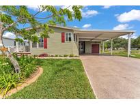 Charming home featuring a covered carport, beautifully landscaped front yard, and a freshly painted exterior at 2101 Cypress Cross Dr, Lakeland, FL 33810