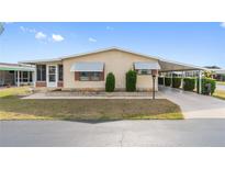Inviting single-story home featuring a covered parking area and well-maintained landscaping at 211 Sweet Cir, Winter Haven, FL 33884