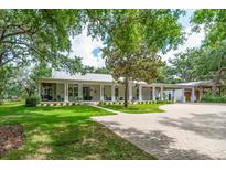 Charming single-story home with a metal roof, wraparound porch, and brick driveway at 2115 W Pipkin Rd, Lakeland, FL 33811