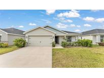 Beautiful single-story home showcasing a well-manicured lawn, an attached two-car garage, and neutral exterior paint at 2611 San Marco Way, Winter Haven, FL 33884