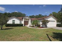 Charming single-story home with lush landscaping, a well-manicured lawn, and a two-car garage at 3359 Sanoma Dr, Lakeland, FL 33811