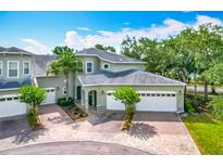 Charming townhome featuring a brick driveway, two-car garage, and well-maintained landscaping in a serene setting at 3852 Serenade Ln, Lakeland, FL 33811