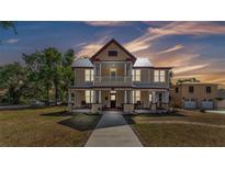 Inviting two-story home featuring a covered front porch, balcony, and metal roof, blending classic charm with modern appeal at 410 S Broadway Ave, Bartow, FL 33830