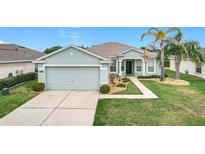 Charming single-story home featuring a well-maintained lawn, two-car garage, and inviting front entryway at 4219 Windchime Ln, Lakeland, FL 33811