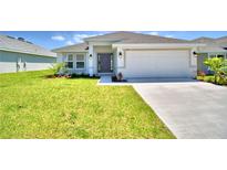 Charming single-story home with a well-manicured lawn and an attached two-car garage at 535 Tanaro Ln, Haines City, FL 33844