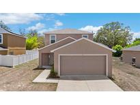 Charming two-story home features a two-car garage and well-maintained landscaping at 11 W Bay St, Davenport, FL 33837