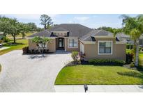 Stunning single-story home featuring a paved driveway, lush landscaping, and a welcoming entrance at 1295 Osprey Landing Dr, Lakeland, FL 33813
