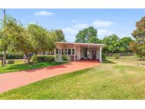 Inviting single-story home featuring a charming carport and well-maintained lawn at 145 Jana Cir, Auburndale, FL 33823