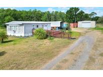 Single Gathering home with ramp access, storage sheds, ample parking, and expansive yard space at 14810 Brahma Rd, Polk City, FL 33868