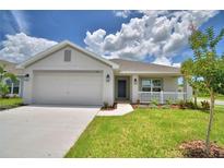 Charming single-story home featuring a two-car garage, landscaped front yard, and covered porch at 1517 Leamington Ln, Winter Haven, FL 33884
