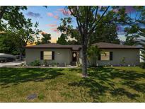 Charming single-story home with a well-maintained lawn and mature trees in a serene neighborhood at dusk at 2103 Sylvester Ct, Lakeland, FL 33803