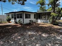 This is a single story home with a screened in porch and an overgrown yard at 2610 Eaton Ave, Lakeland, FL 33803