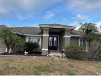Charming single-story home featuring mature landscaping, a covered entrance, and decorative accents at 2663 Brookside Bluff Loop, Lakeland, FL 33813