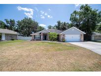 Charming brick home with a well-manicured front yard and attached two-car garage at 2933 Blackwater Oaks Dr, Mulberry, FL 33860