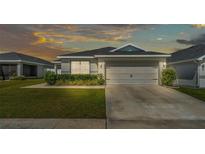 Charming single-Gathering home featuring a well-manicured lawn, a two-car garage, and complemented by lush landscaping at 3946 Willow Ridge Dr, Lakeland, FL 33810