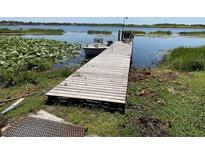 Waterfront property featuring a private dock with access to the lake and a boat at 427 Longfellow Blvd, Lakeland, FL 33801
