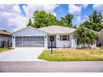 Charming single-story home with a well-manicured lawn and a screened two-car garage, offering curb appeal at 4976 Pleasant Hollow Trl, Lakeland, FL 33811