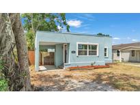 Charming light blue home featuring a covered parking area and a well-kept front yard at 523 W Hancock St, Lakeland, FL 33803