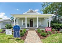 Charming home featuring a welcoming front porch, manicured landscaping, and a brick pathway at 527 W Park St, Lakeland, FL 33803