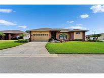 Charming single-story home with a well-manicured lawn, mature landscaping, and a two-car garage at 7890 Ashford Dr, Lakeland, FL 33810