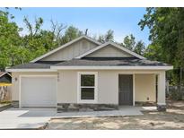 Charming single-story home featuring a neutral stucco facade, stone accents, and an attached one car garage at 950 W 2Nd St, Lakeland, FL 33805