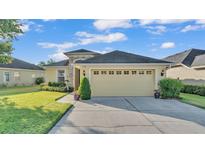 Charming single-story home featuring a manicured lawn, neutral exterior, and a two-car garage at 1036 Stoney Creek Dr, Lakeland, FL 33811