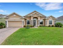Charming single-story home featuring a lush green lawn, stone accents, and a welcoming front entrance at 1470 Silver Leaf Dr, Lakeland, FL 33813