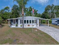Charming single-story home featuring a well-manicured lawn, carport and a covered front porch at 1642 Tally Ho Dr, Lakeland, FL 33810