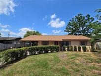 Charming single-story home with tan siding, well-kept bushes, and a neatly maintained front lawn at 1809 Optimist Dr, Lakeland, FL 33801