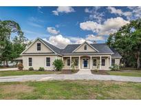 Charming single-Gathering home with a well-manicured lawn, a blue front door and a welcoming front porch at 2070 W Lake Hamilton Dr, Winter Haven, FL 33881