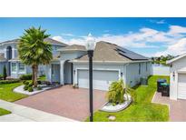 Charming single-story home features a two-car garage, brick driveway, and lush tropical landscaping at 2318 Rush Bay Way, Orlando, FL 32824