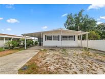 Inviting single-story home featuring a covered parking area and a well-maintained front yard at 3027 Mimosa Way, Lakeland, FL 33801