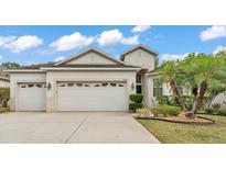 Charming home with a three car garage, well maintained lawn, and tropical landscaping at 3592 Prescott Loop, Lakeland, FL 33810