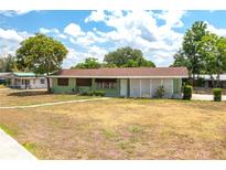 Quaint single-story home with a green exterior, brown roof, and a well-maintained front yard at 400 6Th Ne St, Fort Meade, FL 33841