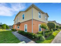 Two-story townhome showcases manicured landscaping, a symmetrical walkway, and a two-tone paint scheme at 4078 Winding Vine Dr, Lakeland, FL 33812