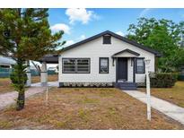 Charming white and dark gray bungalow with well-kept lawn and inviting front entrance at 522 Channing Rd, Lakeland, FL 33805