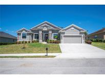 Charming single-story home with well-maintained landscaping, gray stucco, stone accents and a two-car garage at 5531 Pebble Beach Dr, Lakeland, FL 33812